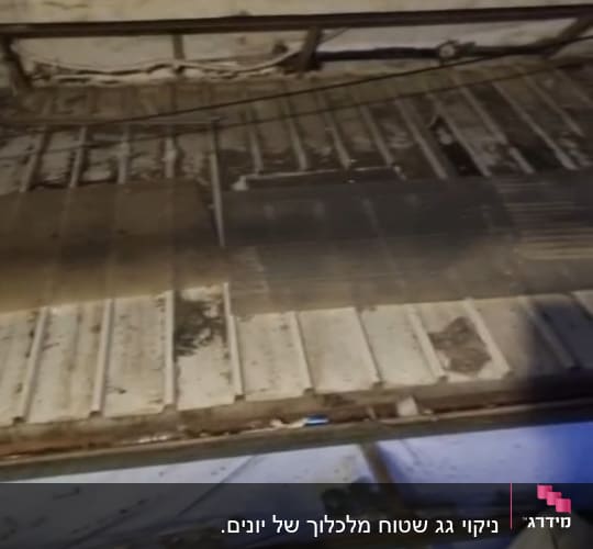 מרפסת עם רצפה מלוכלכת ומעקה ברזל